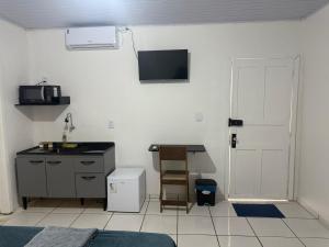 a small kitchen with a sink and a microwave at Flat a 3 minutos do centro de Chapecó in Chapecó