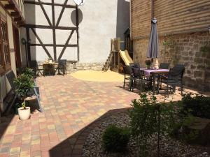 eine Terrasse mit einem Tisch, Stühlen und einem Sonnenschirm in der Unterkunft Ferienhaus am Oeringer Tor in Quedlinburg