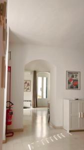 a living room with white walls and a hallway at Giù nei Sassi in Matera