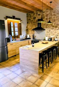 a kitchen with a large island in the middle of a room at Mas Morrenyà - Casa rural in Sant Jaume de Llierca