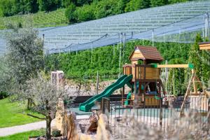 a playground with a slide and a play structure at Apfelhof in Termeno