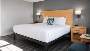 a bedroom with a large bed with white sheets and pillows at Quiet Corner Inn in Brooklyn