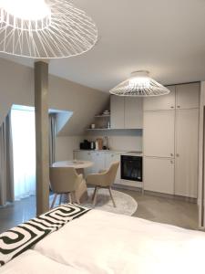 a bedroom with a bed and chairs and a kitchen at Arte Güldenstubbe Residences in Kuressaare