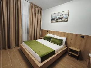 a bedroom with a large bed with green sheets at Matteo Garden & Restaurant in Vlorë