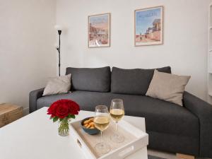 a living room with a couch and two glasses of wine at Le Charmant - plage & restaurants à pied, Houlgate in Houlgate
