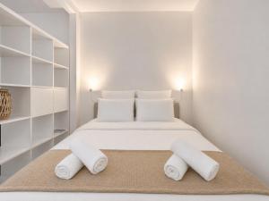 a white bedroom with a bed with two towels at Le Charmant - plage & restaurants à pied, Houlgate in Houlgate