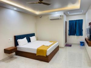 a bedroom with a bed and a ceiling fan at Aish imperial inn in Karaikal