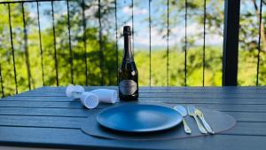 a table with a bottle of wine and a plate and fork at The One Malpensa Rooms in Vizzola Ticino