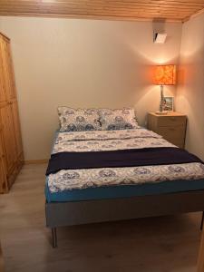 ein Schlafzimmer mit einem Bett und einer Lampe auf einem Nachttisch in der Unterkunft Sandve in Sandve