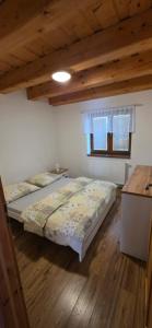 a bedroom with two beds and a wooden floor at Chalupa Chotár in Terchová
