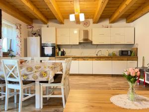 a kitchen with white cabinets and a table and chairs at Chalupa Chotár in Terchová