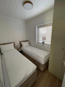 two beds in a small room with a window at Aura Baltic in Rewal +58 photos