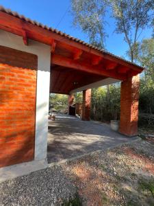 a pavilion with a red brick building at Cabaña Tres linas in Villa General Belgrano