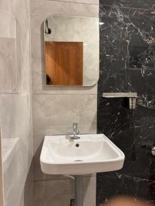 a bathroom with a white sink and a mirror at Aish imperial inn in Karaikal