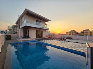 a villa with a swimming pool in front of a house at Kamal in Kārli