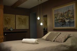 a bedroom with a bed with a painting on the wall at Mas de Bubu in Châteaurenard