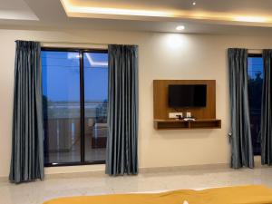 a living room with a tv and a window at Aish imperial inn in Karaikal +17 photos