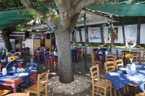 a restaurant with blue tables and chairs under a tree at Villa Tergeste in Trieste