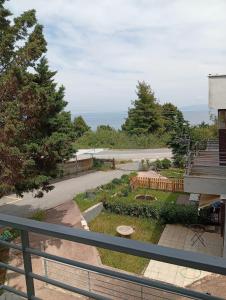 a view of a garden from the balcony of a house at Halkidiki Kallithea Family House across the beach in Kallithea Halkidikis