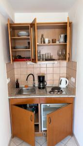 a small kitchen with wooden cabinets and a sink at Apartments Residence Astoria in Rab +95 photos