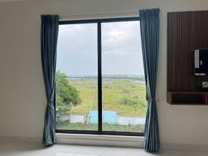 a window with blue curtains in a room at Aish imperial inn in Karaikal