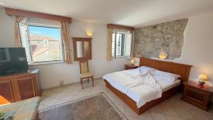 a bedroom with a bed and a tv in it at Apartments Residence Astoria in Rab