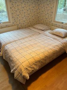 a bed in a bedroom with two pillows on it at Nyrenoverad stuga mellan två sjöar in Järlåsa