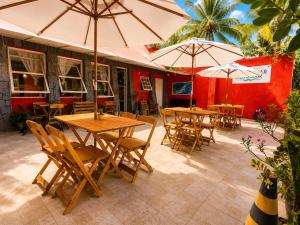 a group of tables and chairs with umbrellas on a patio at Pousada Mojomar Buzios in Búzios
