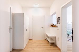 a hallway with white walls and a desk and doors at Apartment in Bayreuth in Bayreuth