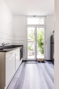 a kitchen with white cabinets and a large glass door at Apartment in Bayreuth in Bayreuth