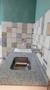 a stainless steel sink in a kitchen with tiles at Namasté in Villa Larca