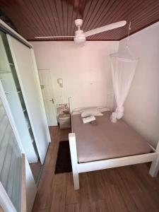 a bedroom with a bed and a ceiling fan at Pépite Anses in Les Anses-dʼArlets