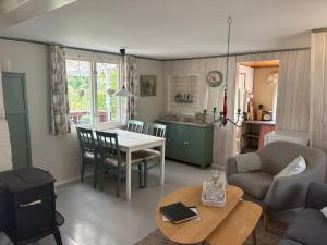 a living room with a table and a kitchen at Hus Sinnermåla in Högsby +18 photos