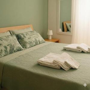 a bed with two towels sitting on top of it at Torres House Suite & Rooms in Sassari +2 photos