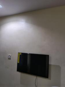 a flat screen tv hanging on a wall at Bec property in Ikorodu