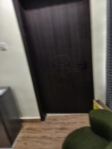 a black door in a room with a green chair at Bec property in Ikorodu