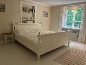 a bedroom with a white bed and a window at Hus Bokhultet in Ruda