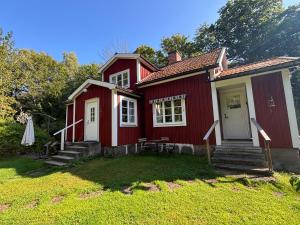 a red house with a lawn in front of it at Hus Bokhultet in Ruda