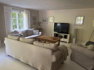 a living room with two couches and a tv at Hus Bokhultet in Ruda