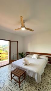 a bedroom with a bed and a ceiling fan at La Casa de la Vall in Castellbell i Vilar +7 photos