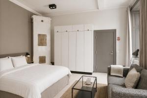 a bedroom with a bed and a couch and a chair at Guldgränd in Stockholm