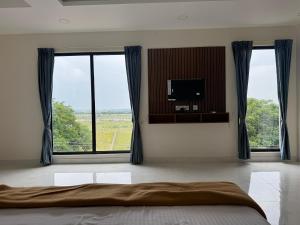 a bedroom with a bed and two large windows at Aish imperial inn in Karaikal