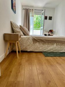 a bed in a room with a table and a window at Escale Rennes in Rennes