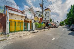 an empty street with a building with a yellow door at Roemah Noni Baciro By ARBA in Demangan