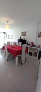 a dining room with a red table and chairs at Rincón de Candelaria in Solórzano