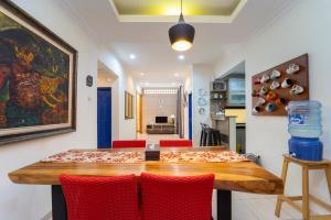 a dining room with a table and red chairs at Roemah Noni Baciro By ARBA in Demangan