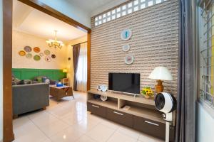 a living room with a tv on a brick wall at Roemah Noni Baciro By ARBA in Demangan