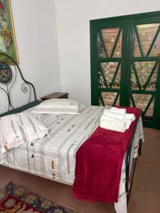 a bedroom with a bed with a red blanket on it at Paraíso com piscina e lareira no centro in Serra Negra +18 photos