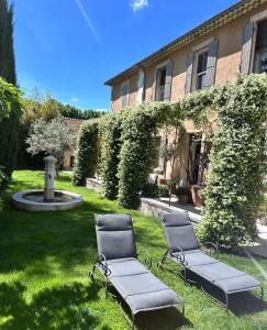 two chairs in the grass in front of a building at Les Tilleuls in Cavaillon