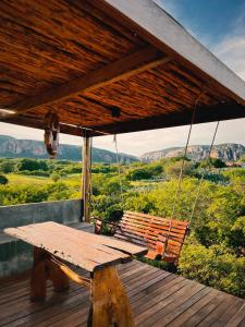 a wooden porch with a swing on a deck at Chalé Caroá in São Raimundo Nonato